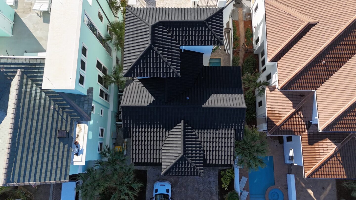 Aerial view of a coastal home with a TEK metal tile roof
